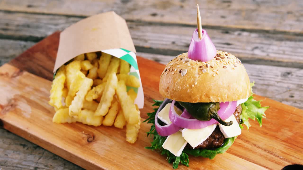 hamburguesa y papas fritas en tablero de madera