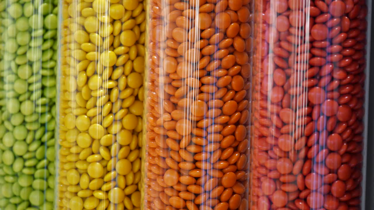 dulces de colores en recipientes cilíndricos