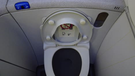 airplane bathroom toilet with lid open up-down panning view