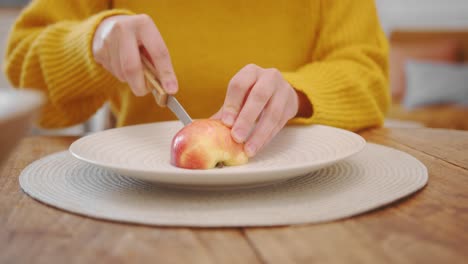 young healthy woman cut fresh apple in half, front view