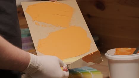 a worker applies a paint sample to a palette for color verification