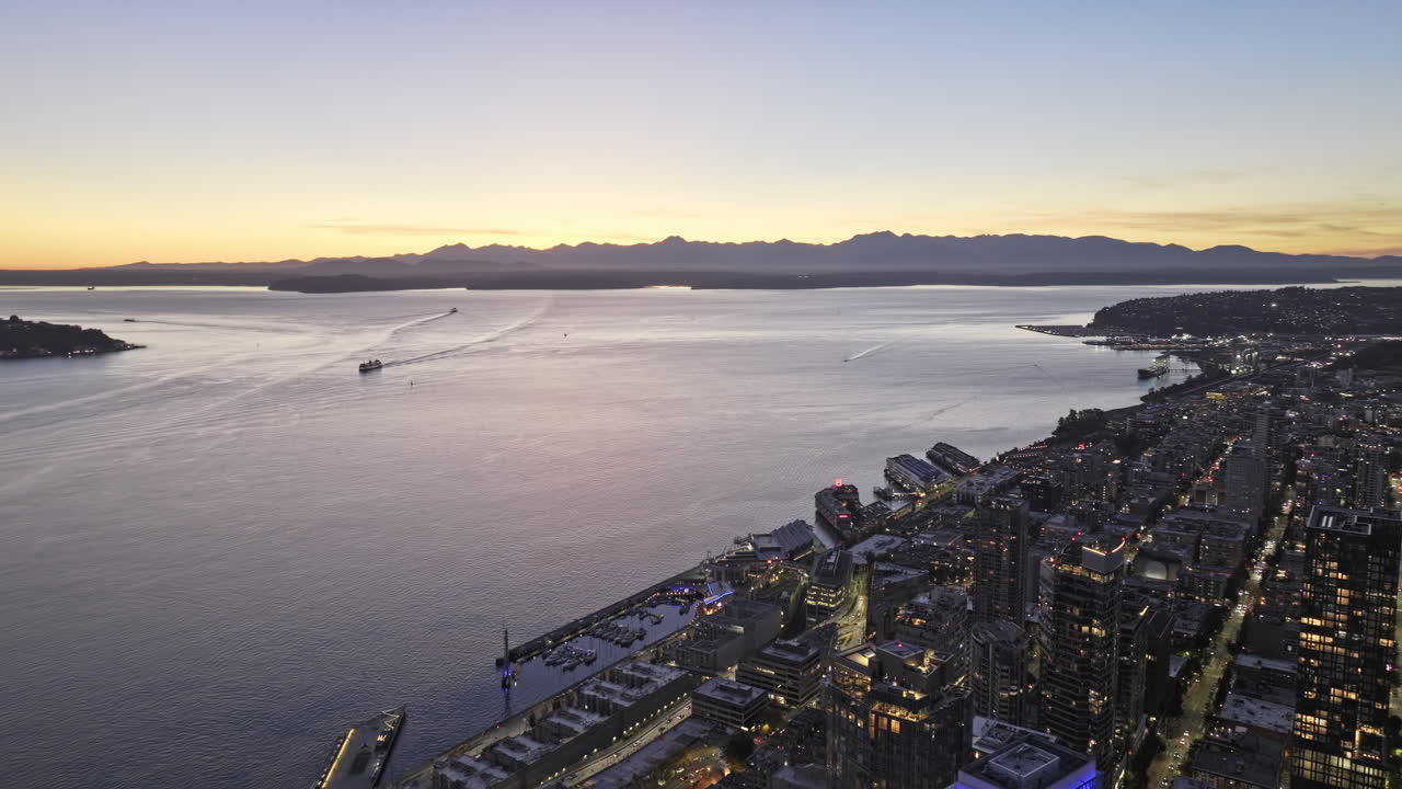 Seattle Washingtonin ilmakuva v200 keskustan yli lentäen, vangiten Belltownin ranta-alueen, Elliott Bayn, näkymät Uptownin ja Queen Annen kaupunginosista auringonlaskun hämärässä – Kuvattu Mavic 3 Pro Cine -kameralla – 6. lokakuuta 2023.