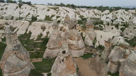 toma aérea hacia atrás del paisaje rocoso con una formación rocosa inusual llamada chimeneas de hadas en goreme, capadocia, turquía