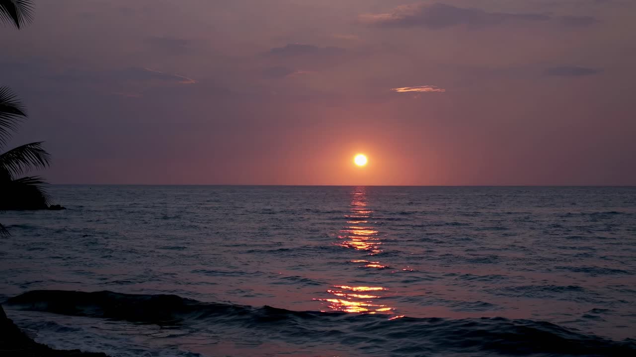 A serene sunset over the ocean captured from a low-angle perspective, ideal for a calming video