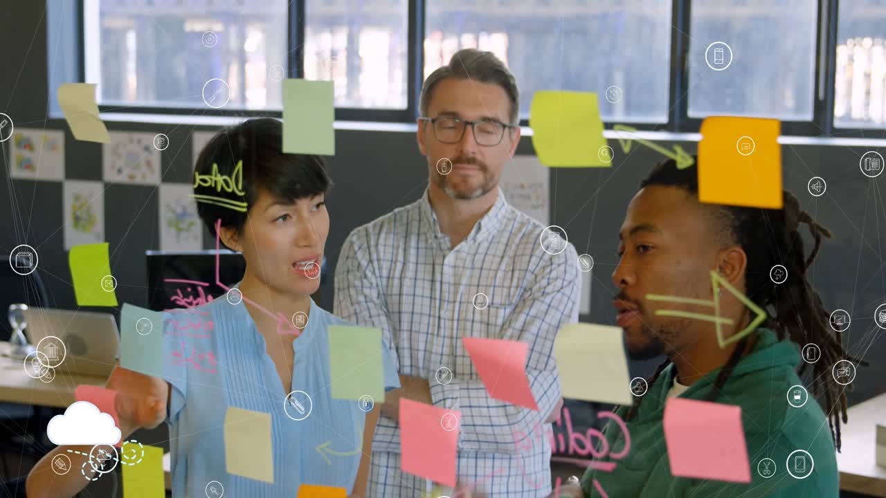 Animation of connected icons over diverse colleagues brainstorming over sticky notes on glass wall
