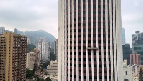 una plataforma suspendida de limpieza de ventanas de gran altura colgando de un rascacielos en hong kong