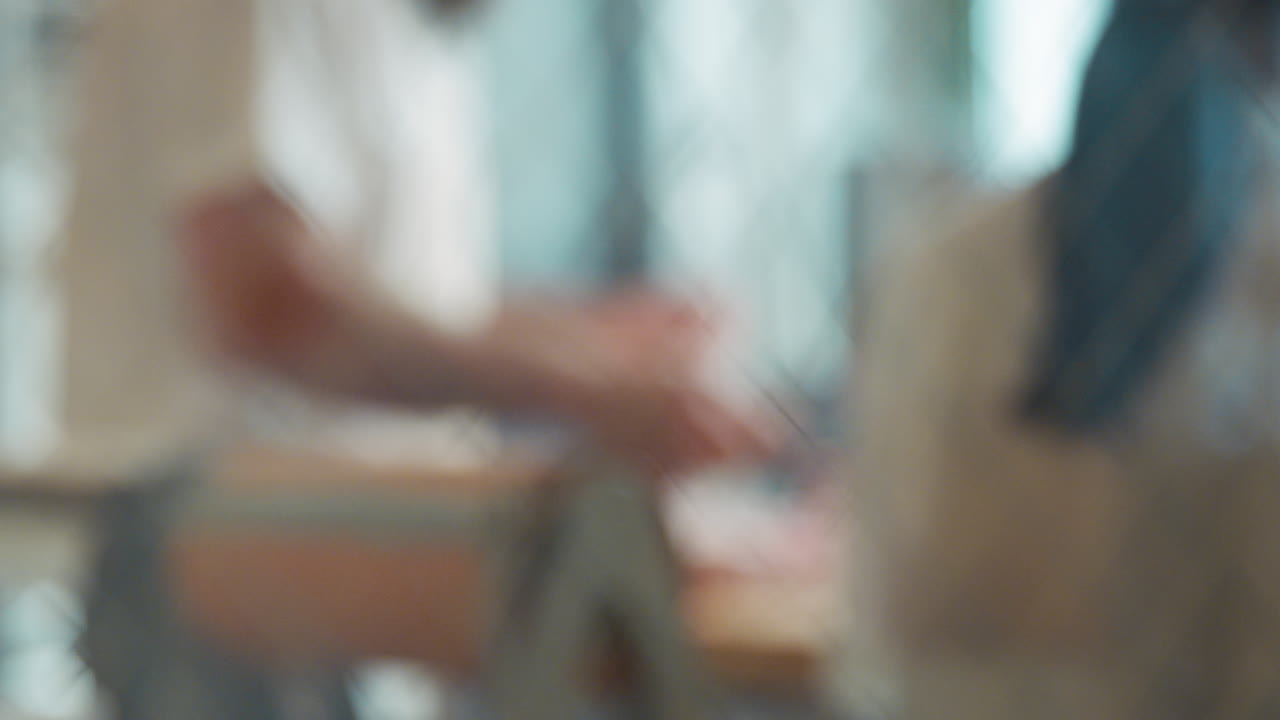 Butchers cutting meat at butcher's shop, seen through window