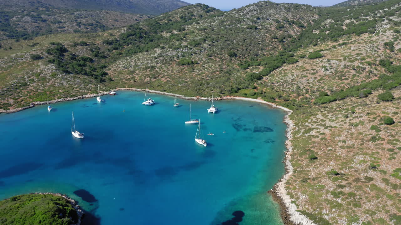 Aerial: Sailboats and catamarans on the bay of the Greek island of Kira Panagia in Northern Sporades, Greece