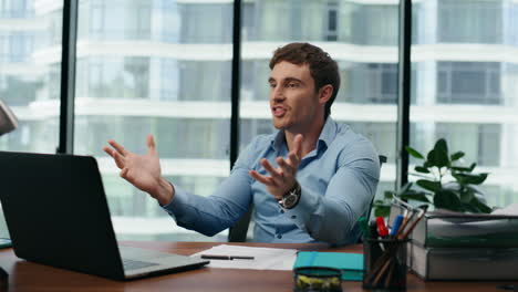 Man-talking-colleagues-video-chat-sitting-office-close-up.-Worker-using-laptop.