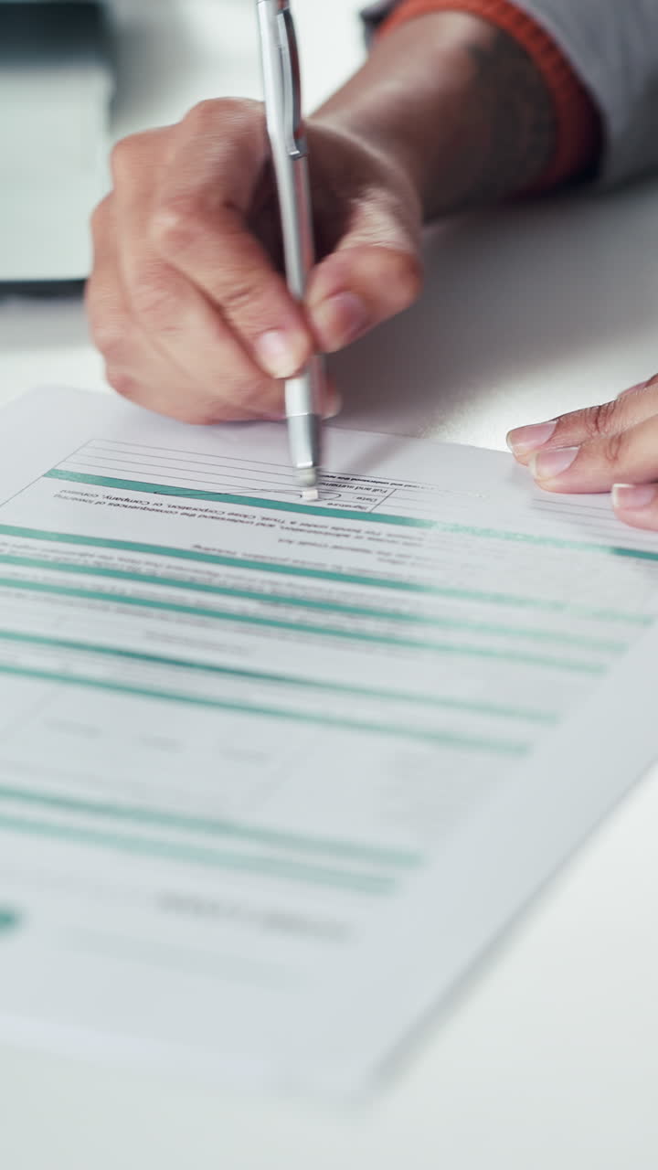 Primo piano di una mano che scrive su un documento con una penna