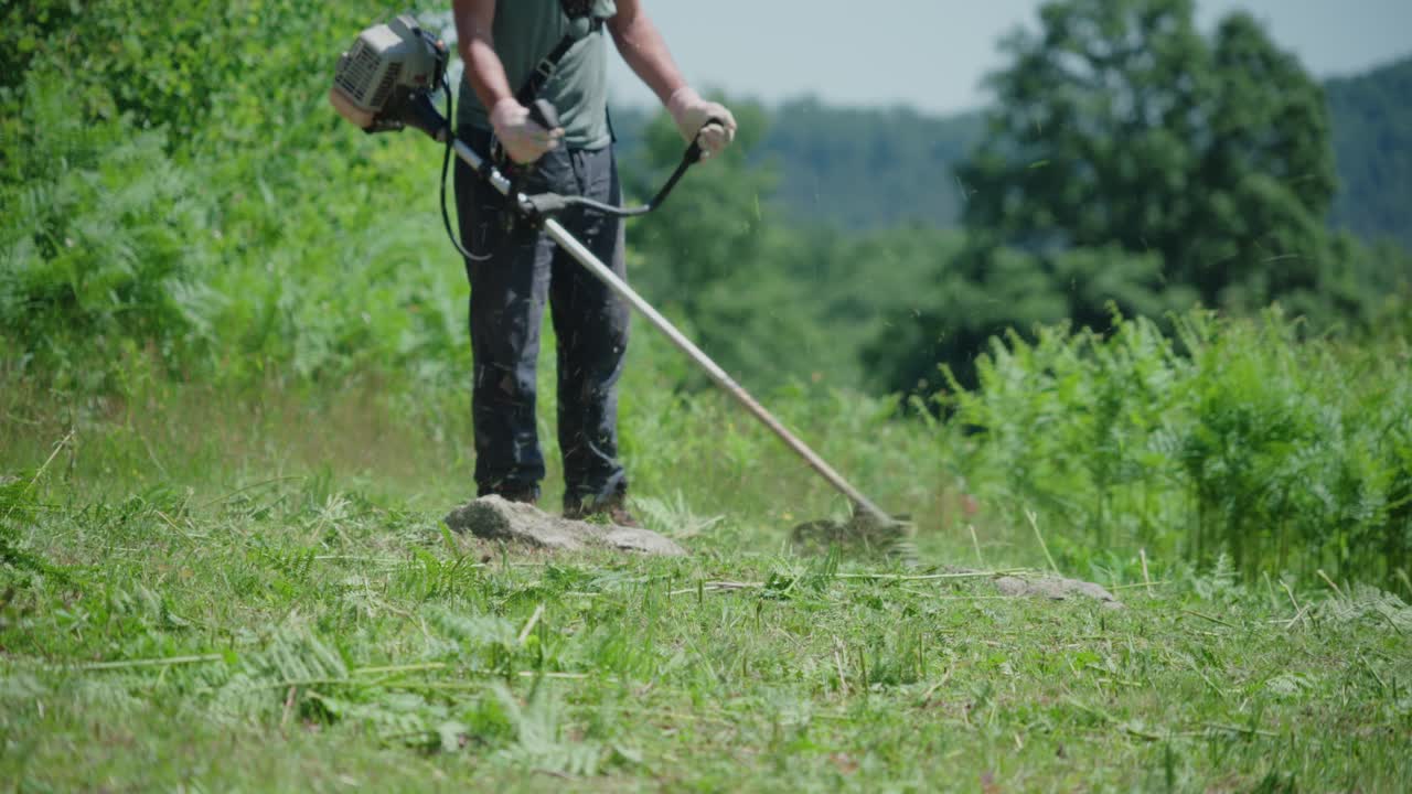 Man manually moving weeds from his plot of land. Static at day time