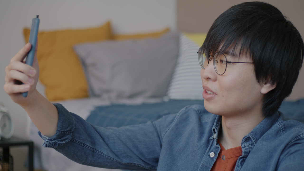 Young Man Taking a Selfie in His Bedroom
