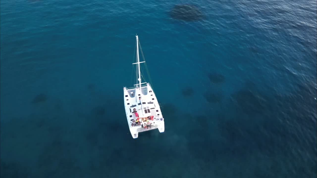 dando vueltas alrededor de un catamarán y revelando la costa