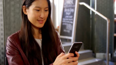 Woman-using-mobile-phone-at-restaurant-4k