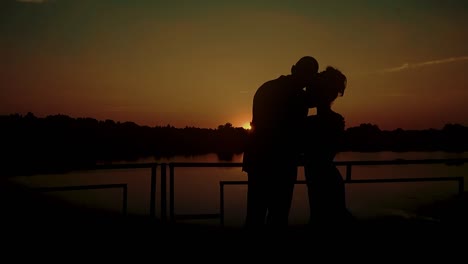 Two-young-people-hugging-against-the-backdrop-of-a-sunset-by-the-river-close-up-2