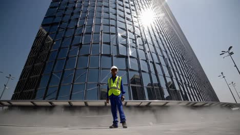 construction worker in front of modern skyscraper
