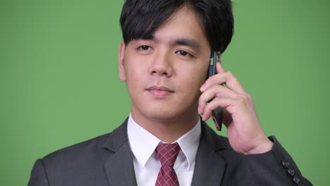 joven y guapo hombre de negocios asiático usando un teléfono móvil