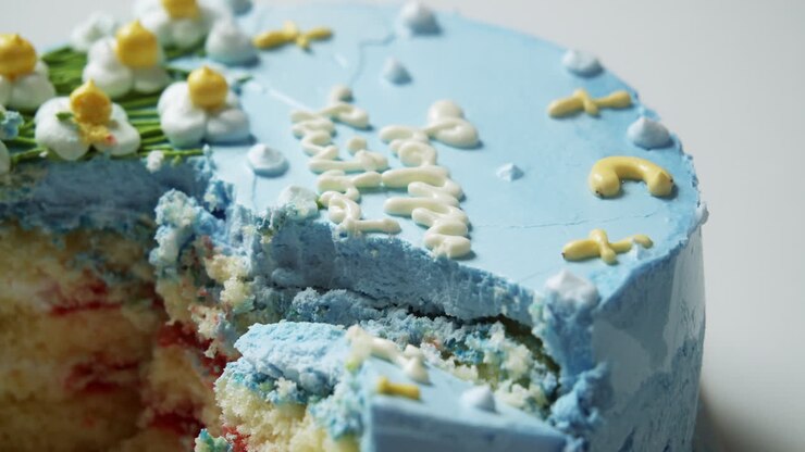 Taglio di una torta a strati soffice, ripiena di una ricca farcitura alle fragole, guarnita con una glassa al burro blu deliziosamente morbida, dolce e squisita.