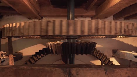 close up on a section of an interior gear mechanism of a water mill, composed by two cogwheels working together to creat movement to grind cereals into flour