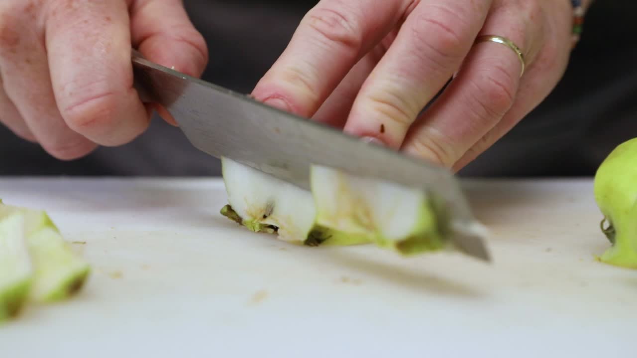 도마 위에서 녹색 사과를 자르는 여자 - 클로즈업, 슬로우 모션 촬영