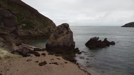 Tiro-Deslizante-De-Paisaje-Marino-Pacífico,-Playa-Rocosa-De-Porth-Wen,-Reino-Unido