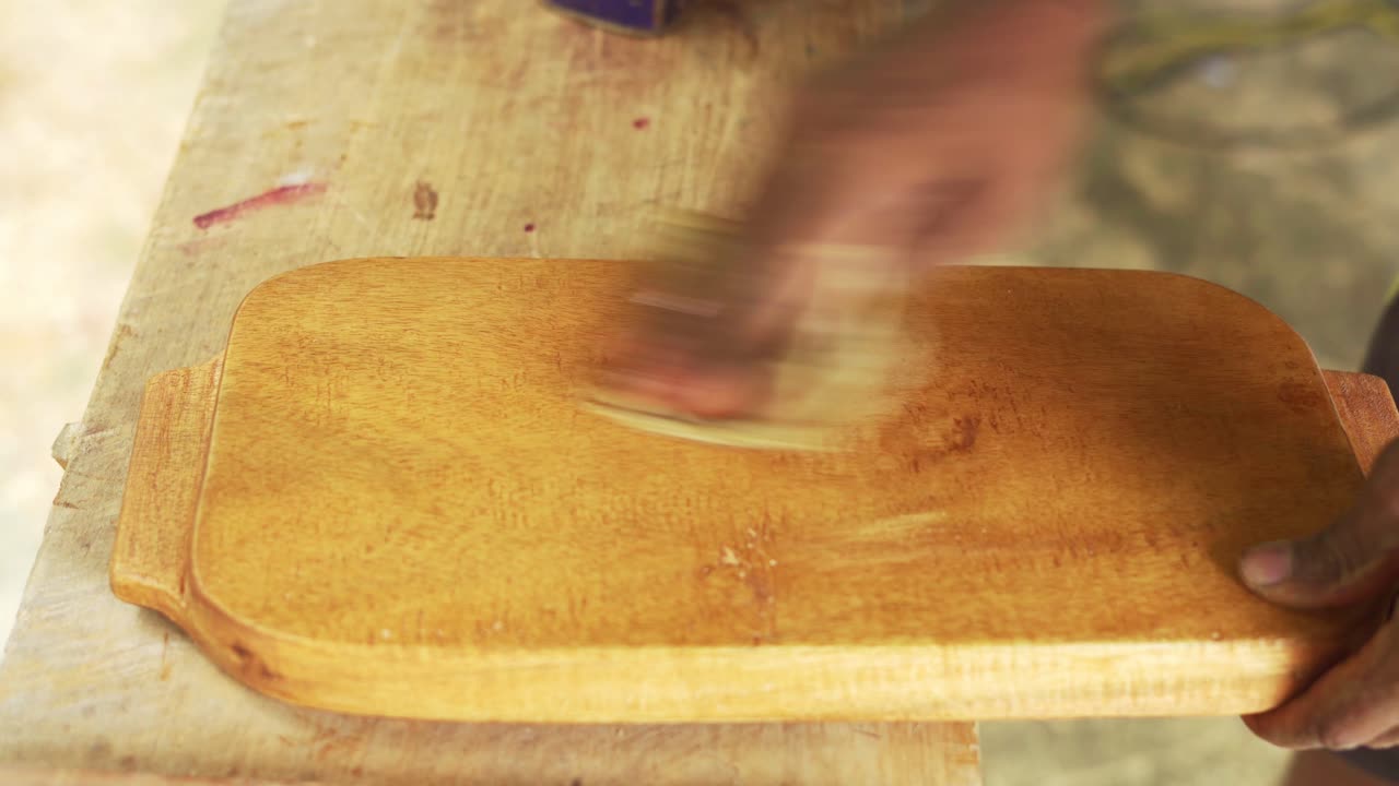 limpieza manual de una tabla de cortar de madera en el taller