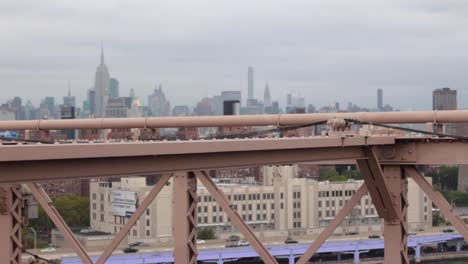 brooklyn bridge beams with manhattan skyline in the background