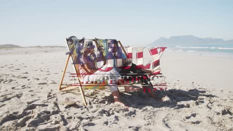 texto del día de la independencia contra la pareja caucásica mayor sentada en sillas de cubierta en la playa
