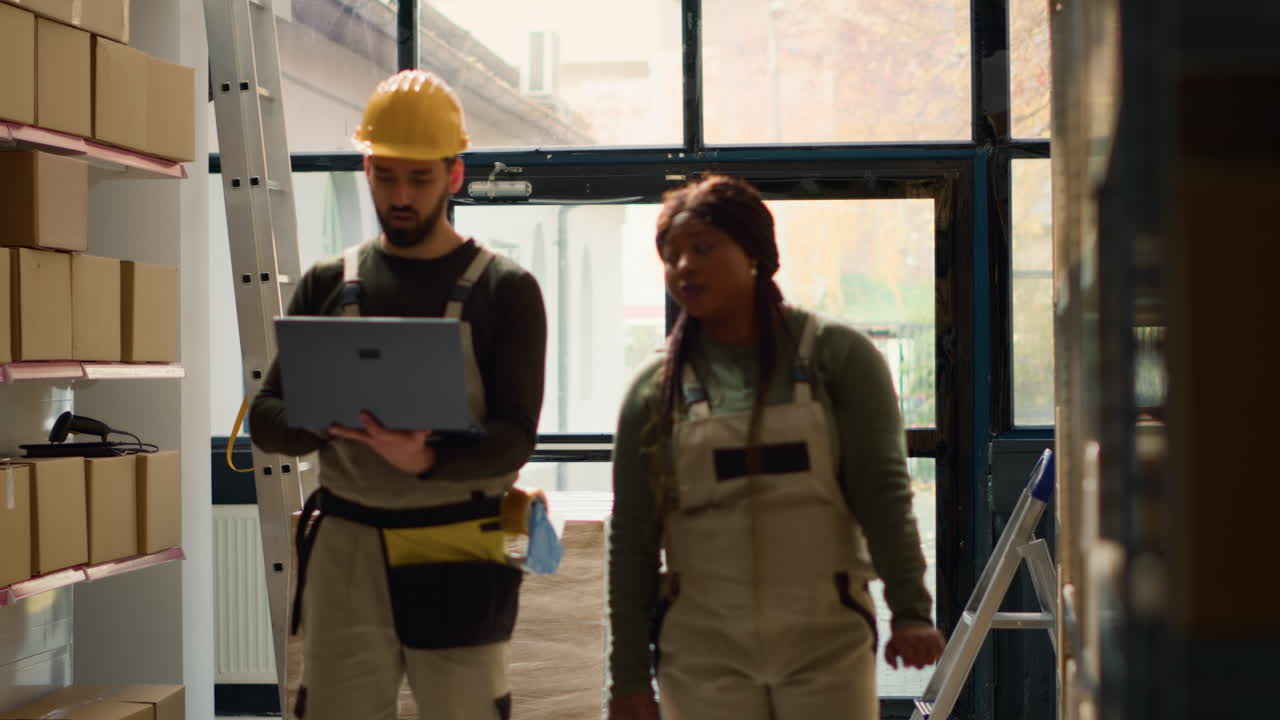 Warehouse workers checking inventory with laptop