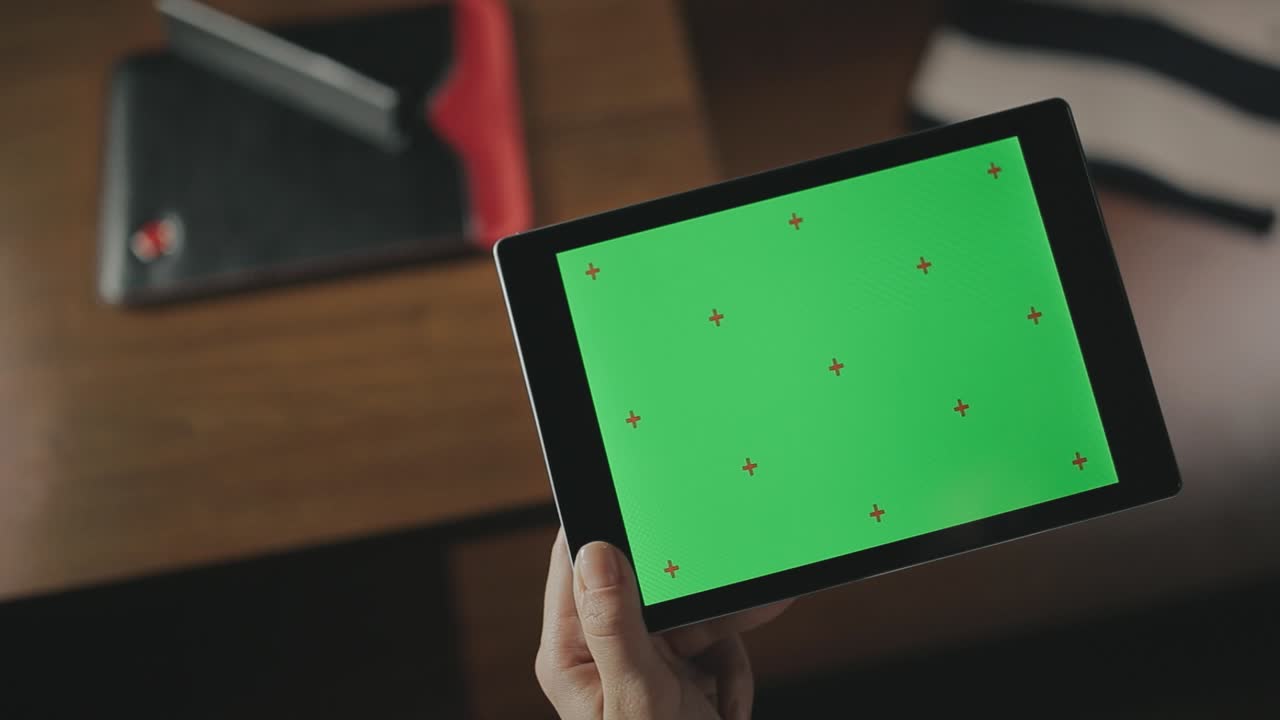 mujer con la mano sosteniendo una tableta. mujer tocando una tableta con pantalla verde