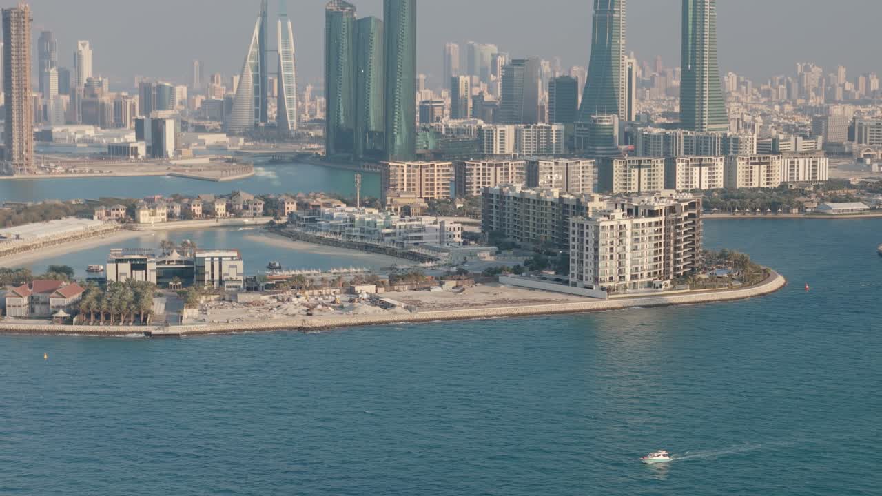 Manama Bahrain, Reef Island and downtown skyline with small boat in foreground, aerial drone shot