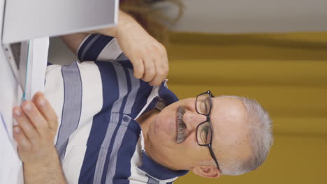 Vertical-video-of-Home-office-worker-old-man-is-disgusted.