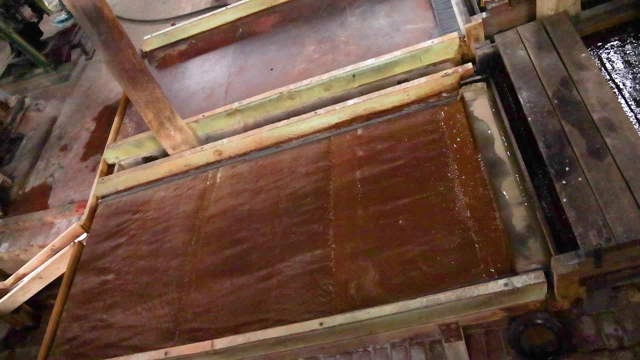 Wooden sawmill machinery in action, showcasing traditional techniques. Natural lighting highlights the rustic environment and mechanical movement