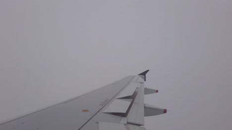 airplane wing in thick zero visibility clouds