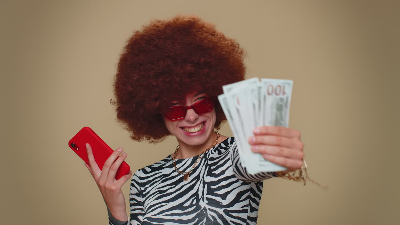 Happy young woman use smartphone rejoicing win, receiving money cash , success lottery jackpot luck