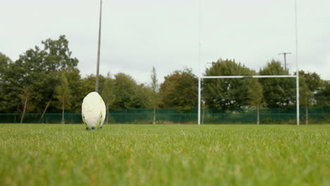 close up of a rugby player kicking a rugby ball