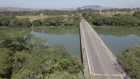 aerial-view-of-a-large-river-bridge-going-over-and-over-the-side-and-through-the-trees-to-the-other-side