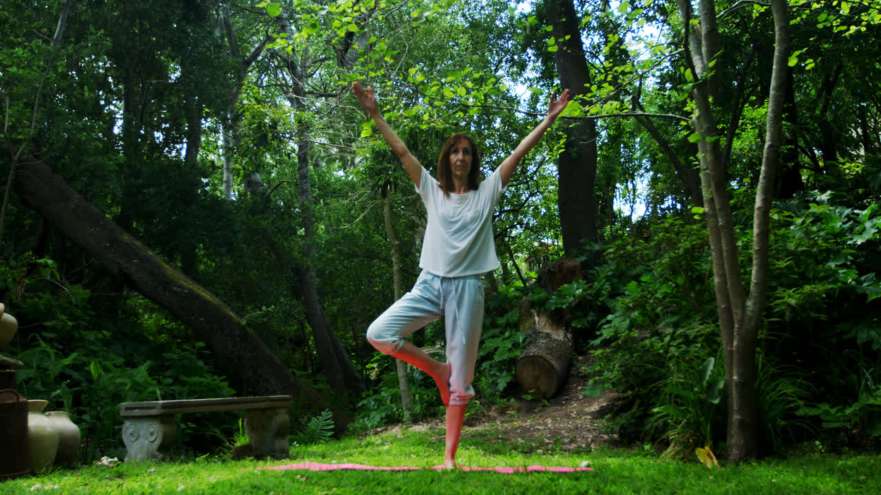 Donna matura che pratica yoga nel parco 4K.