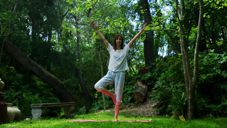 mature woman performing yoga in the park 4k