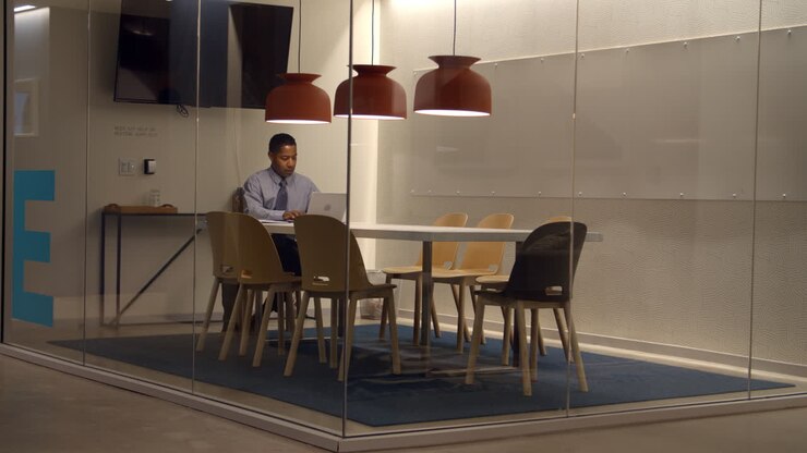 Uomo d'affari nero che lavora in un cubicolo in un'azienda.