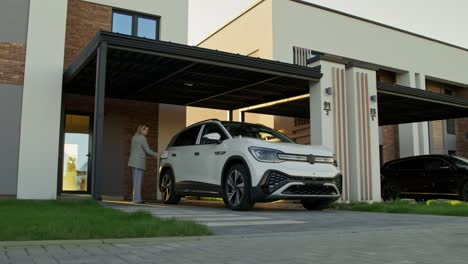 woman opening car door in front of a house