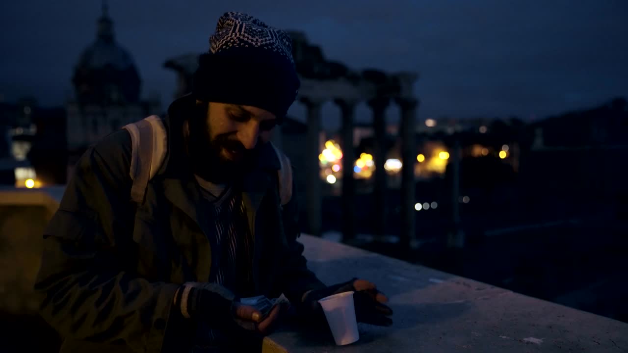 счастливый улыбающийся бездомный в ночь подсчитывает свои деньги