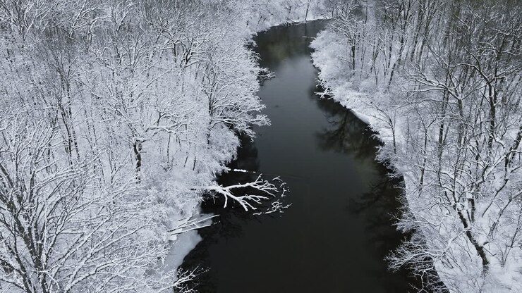 A drone's-eye journey above the snow-covered Huron River Valley, capturing its tranquil allure