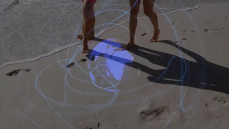 Animation-of-globe-rotating-with-wave-pattern-over-low-section-of-caucasian-couple-walking-on-beach