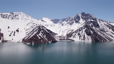 snow-covered mountain with el yeso dam in foreground in chile