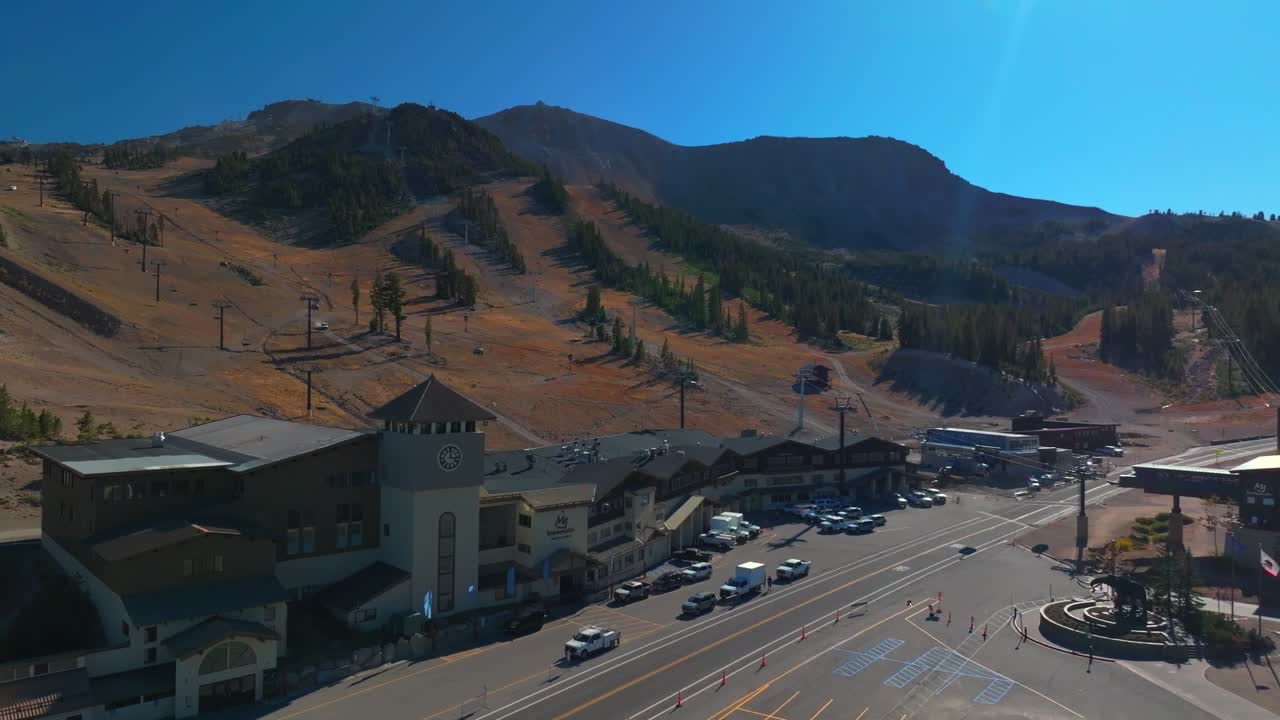 Mammoth Lakes Mountain Ski Area McCoy Station Main lodge Minarets Upper Panorama Gondola summer autumn fall aerial drone California parking lot cars sunny daytime blue sky chairlift gondola left pan