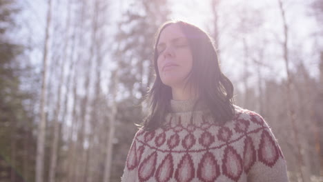 high key medium shot of european woman with eyes closed meditating in nature