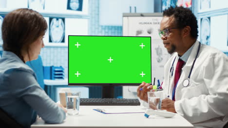 Afroamerikanischer-Sanitäter-Zeigt-Auf-Greenscreen,-Während-Er-Einen-Patienten-Berät