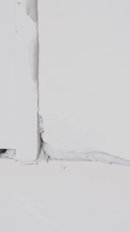 worker knocks and moves white gypsum pasteboard construction to corner with grey glue extreme close view