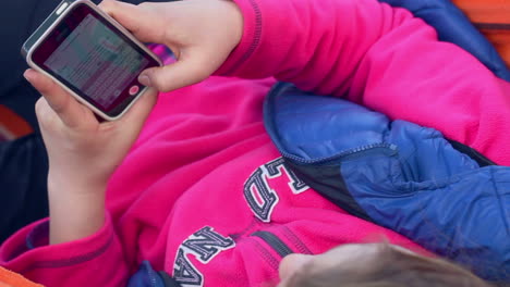 girl typing text on mobile phone. woman texting on smart phone. top view